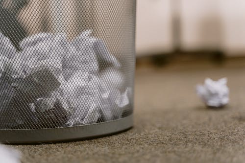 Free Crumpled Papers in a Mesh Trash Can Stock Photo