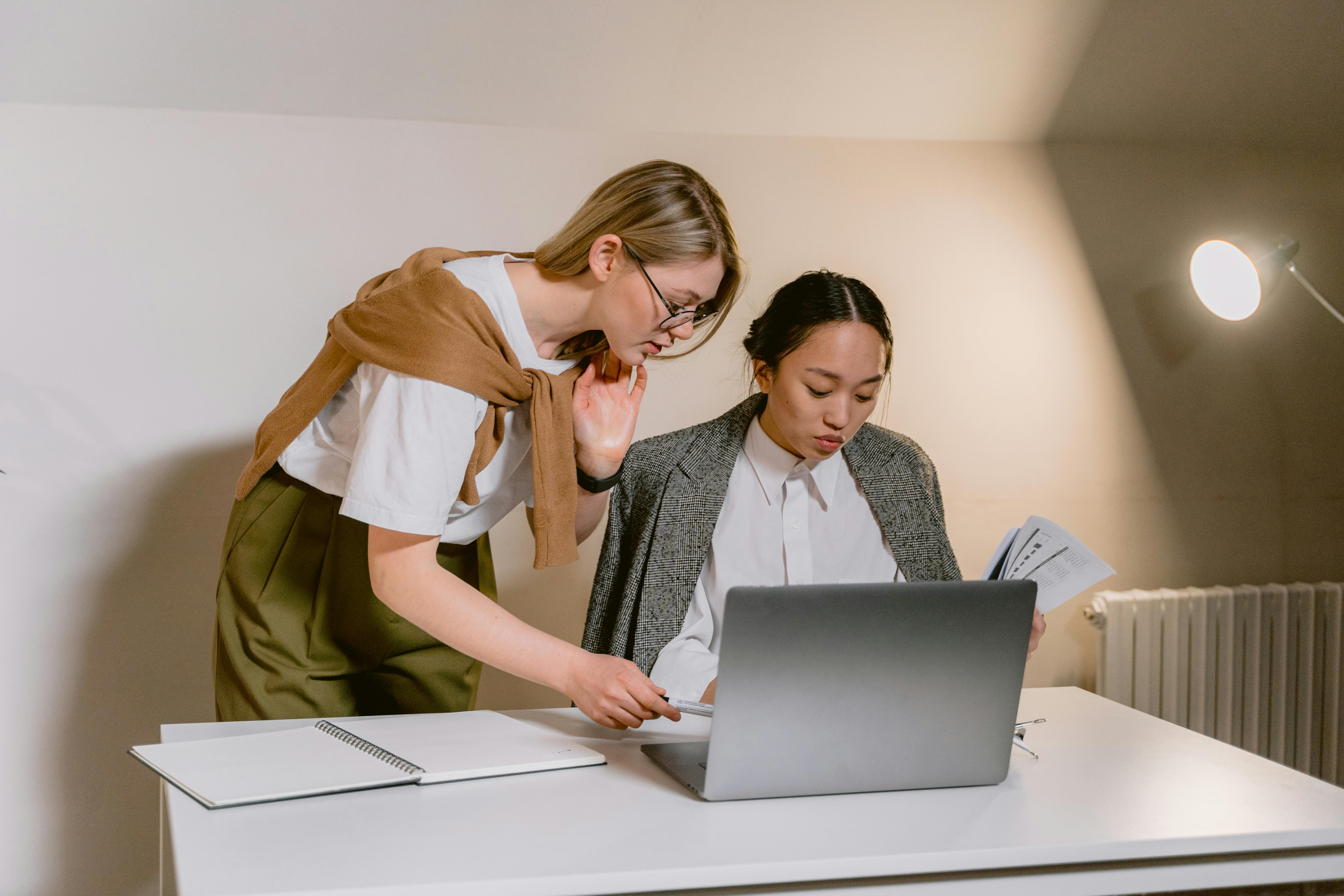 woman in white shirt using laptop computer