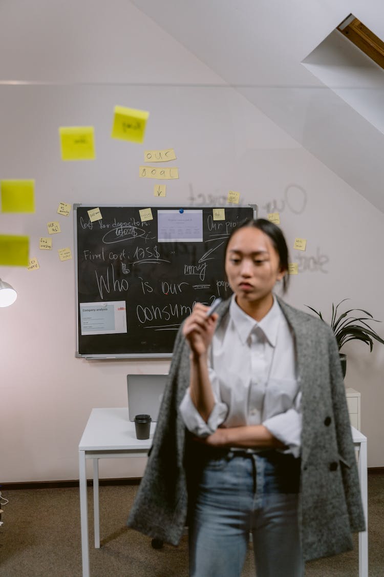 Pensive Professional Woman In White Dress Shirt And Gray Coat 