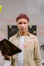 Man in Red Knit Cap and White Button Up Shirt Holding Black Lenovo Laptop