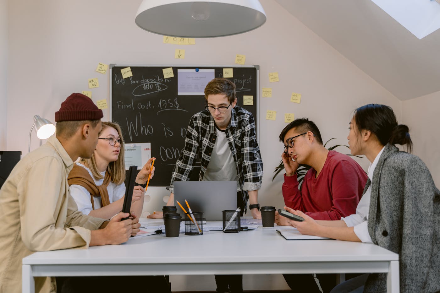 Diverse team brainstorming together around a table in a bright office setting.