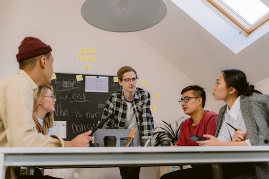 A diverse group of adults collaborating on a project in an office with a focus on creative brainstorming.