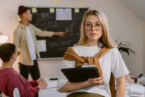 Free Business team engaged in project planning with blackboard and tablet in modern office. Stock Photo