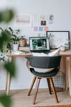 Modern workplace with table and green potted fresh plants near netbook in daylight