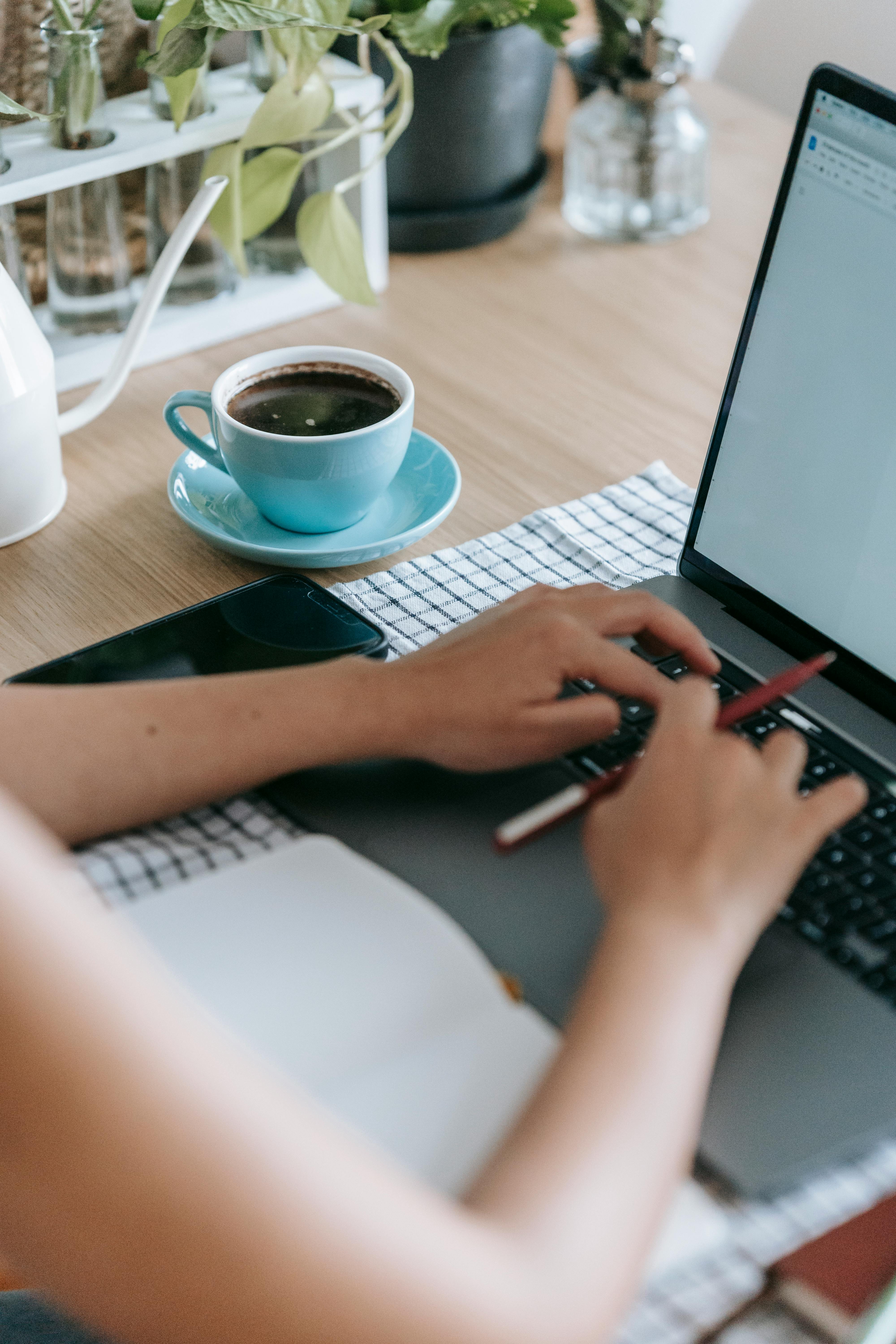 woman working on project with laptop at table with coffee