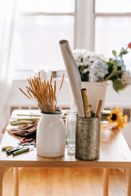 Free Wooden table with flowers and tools in light room Stock Photo
