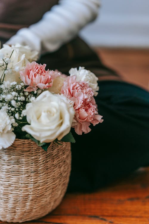 Unrecognizable person near flowerpot with various flowers