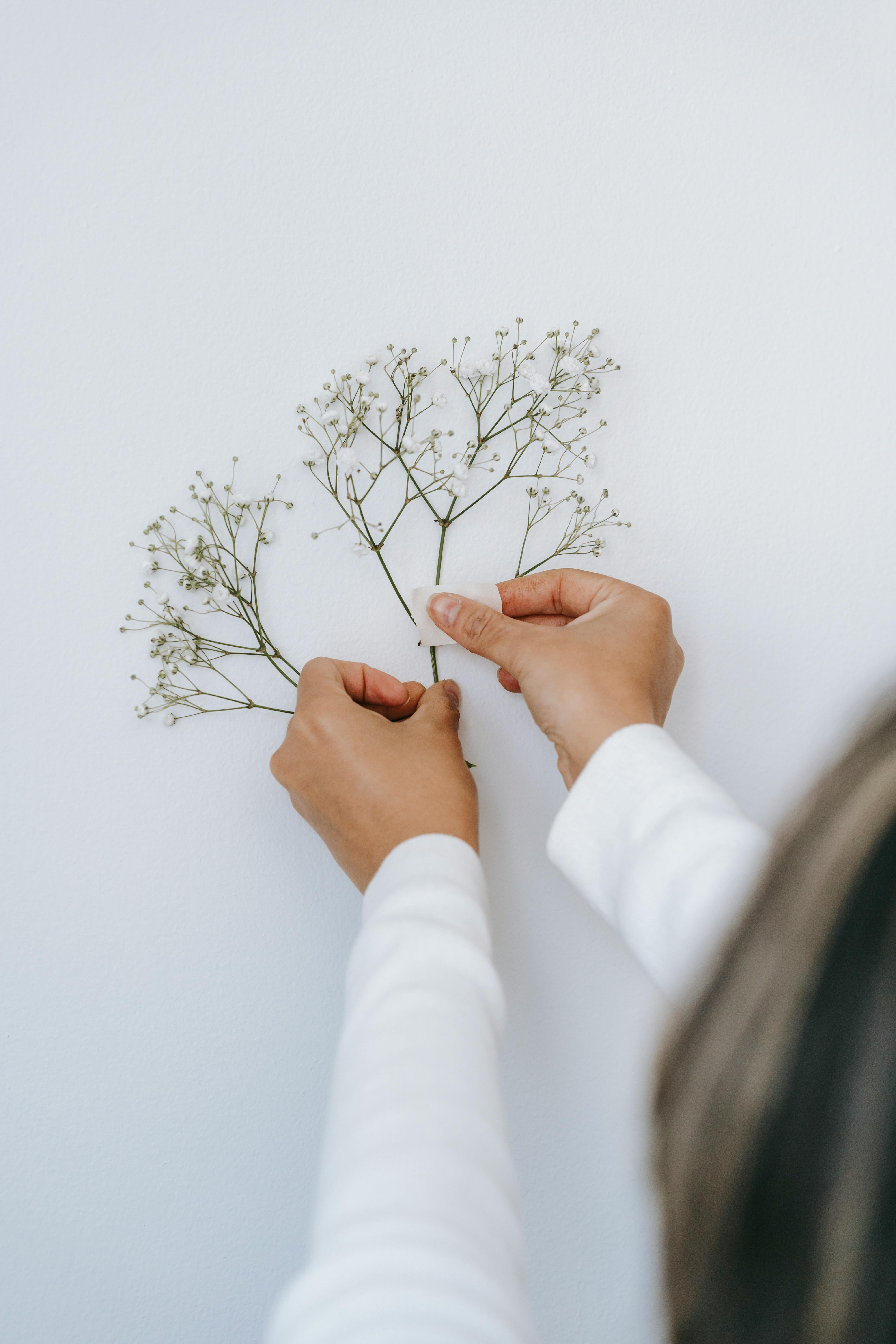 unrecognizable person attaching twig on wall