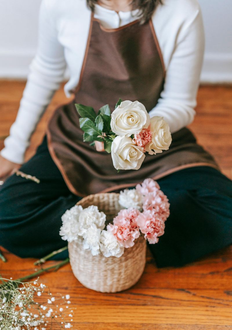 Our florist holding fresh roses and a basket of blooms