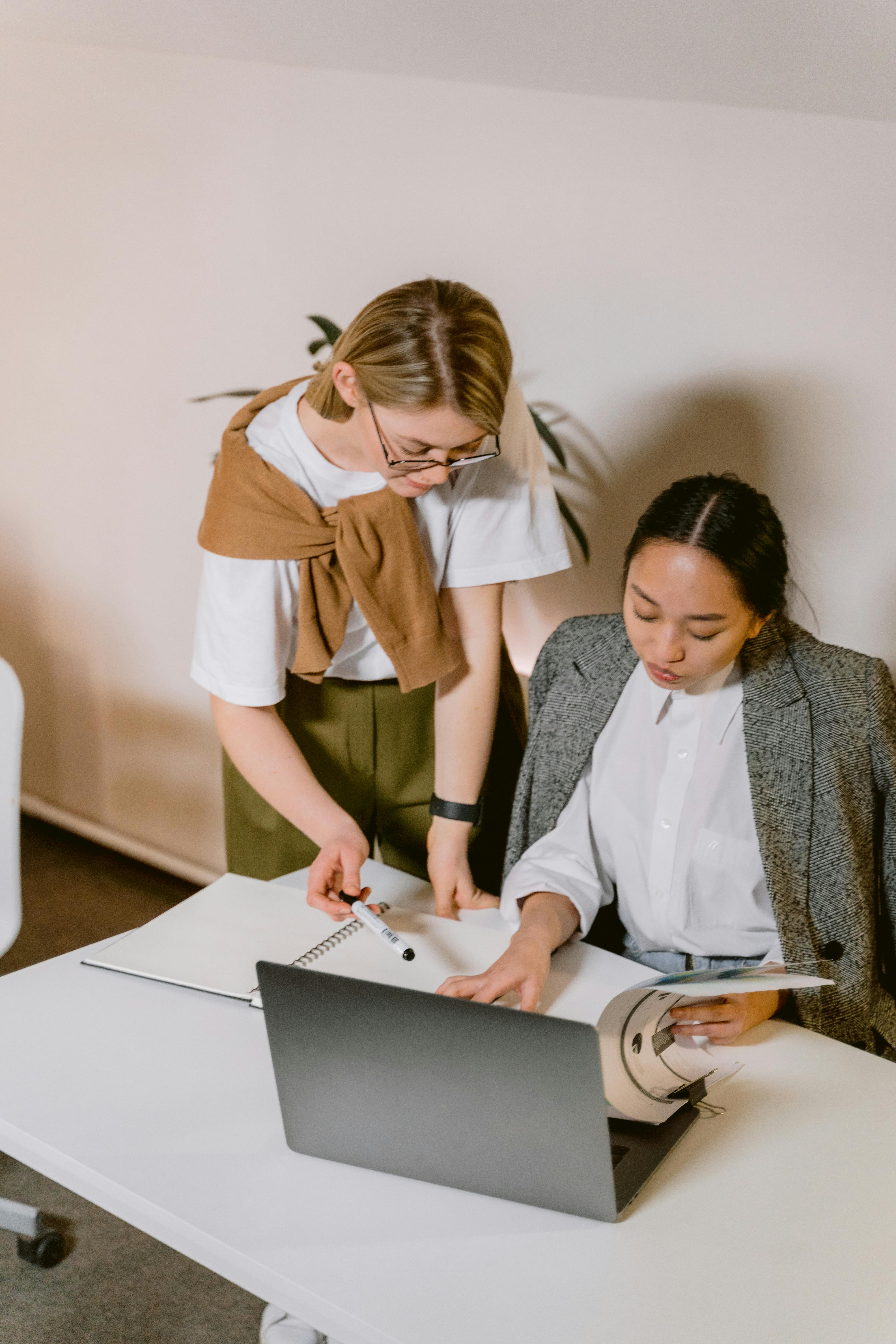 woman in white button up shirt using silver macbook