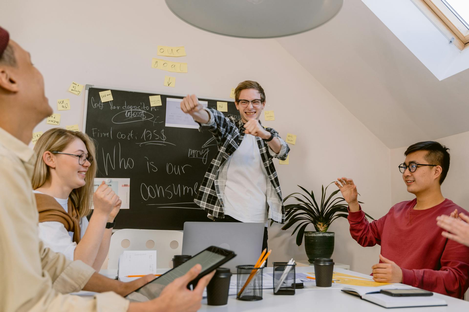 Young professionals in a vibrant office celebrating a team success with smiles and enthusiasm.