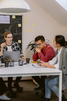 A diverse group of young professionals brainstorming in a modern office setting.