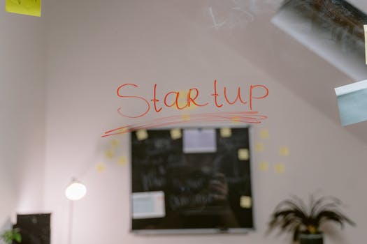 Close-up of 'Startup' written on a glass panel in an office setting.