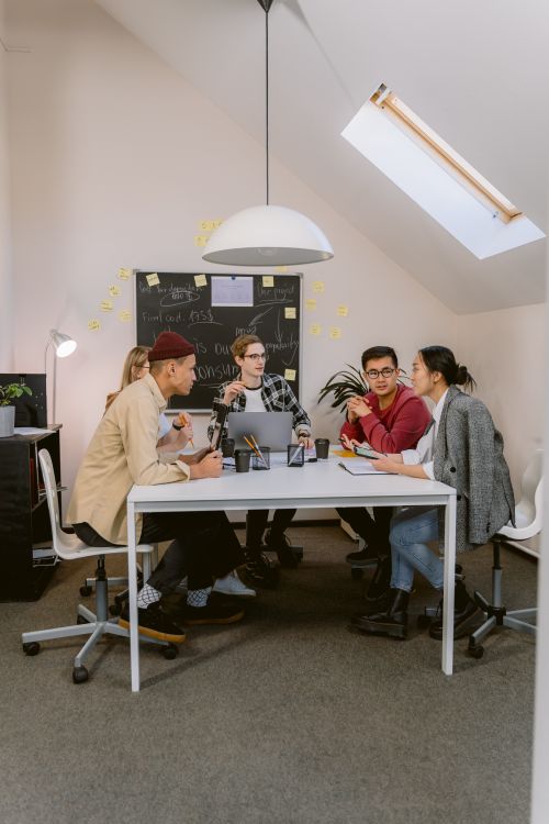 Free Diverse team collaborating in a stylish office setting, fostering innovation and teamwork. Stock Photo