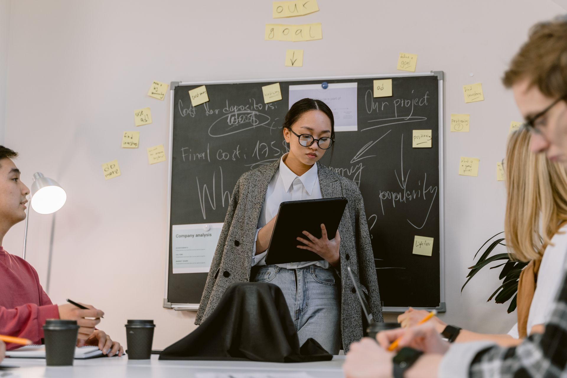 Young woman presenting a business strategy during a team meeting in a modern office.