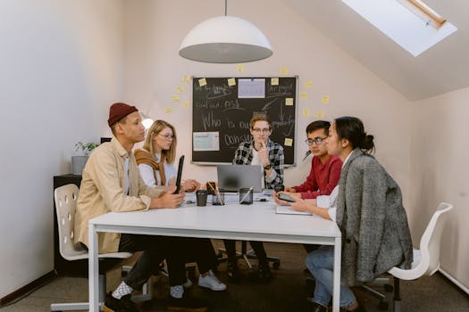 A diverse group of coworkers engaged in a brainstorming session at a modern office table.
