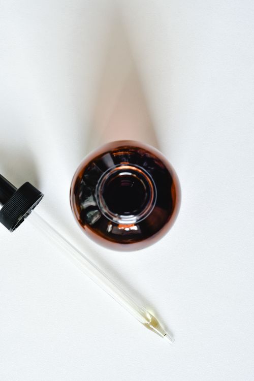 Free Close-up view of a brown glass bottle with a pipette on a white background. Stock Photo