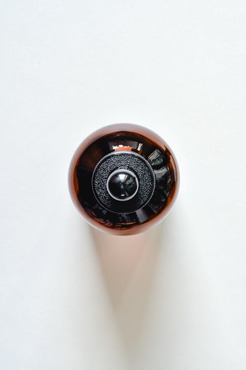 Brown and Black Round Glass Container on a White Background