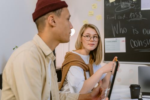 Free Two young professionals engaged in a collaborative office meeting with brainstorming ideas. Stock Photo