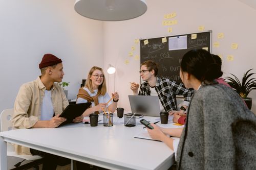 Free Young professionals collaborating in a modern office setting, fostering teamwork and innovation. Stock Photo