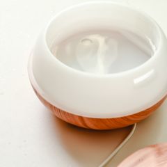 A white and wood-grain diffuser on a pale table