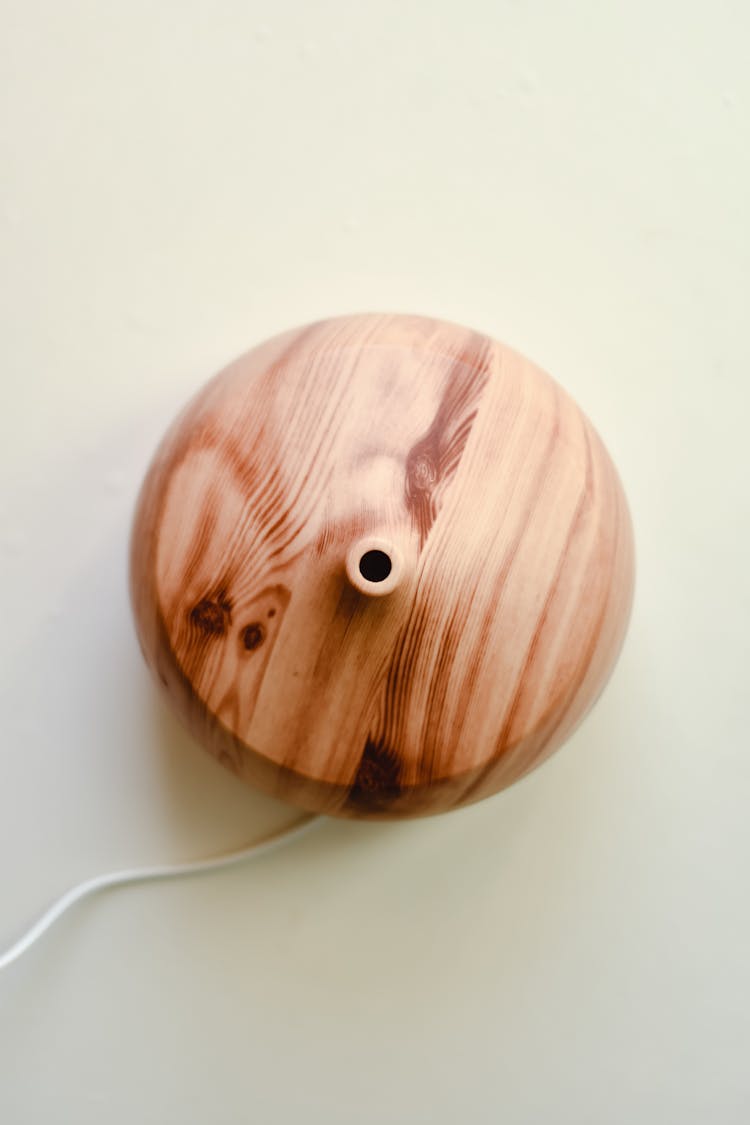 A Wooden Diffuser With Electric Cord On A White Surface