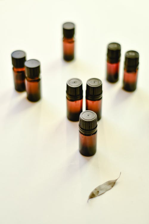 Brown Bottles of Essential Oils on White Surface