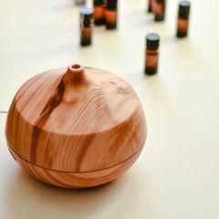 A wood-grain teardrop diffuser with essential oil bottles