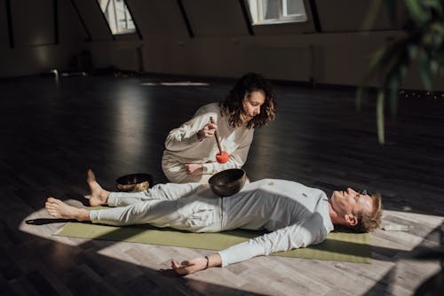 Free Singing Bowl on a Man Lying on Yoga Mat  Stock Photo