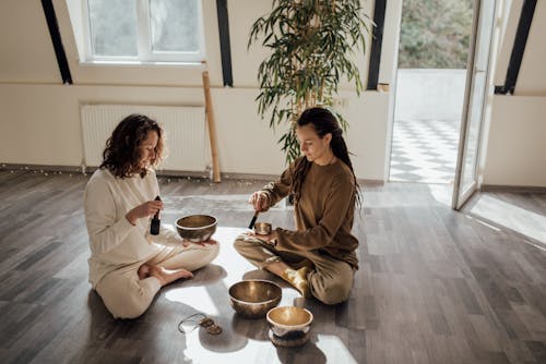 Women Sitting on Floor Using Tibetan Singing Bowls