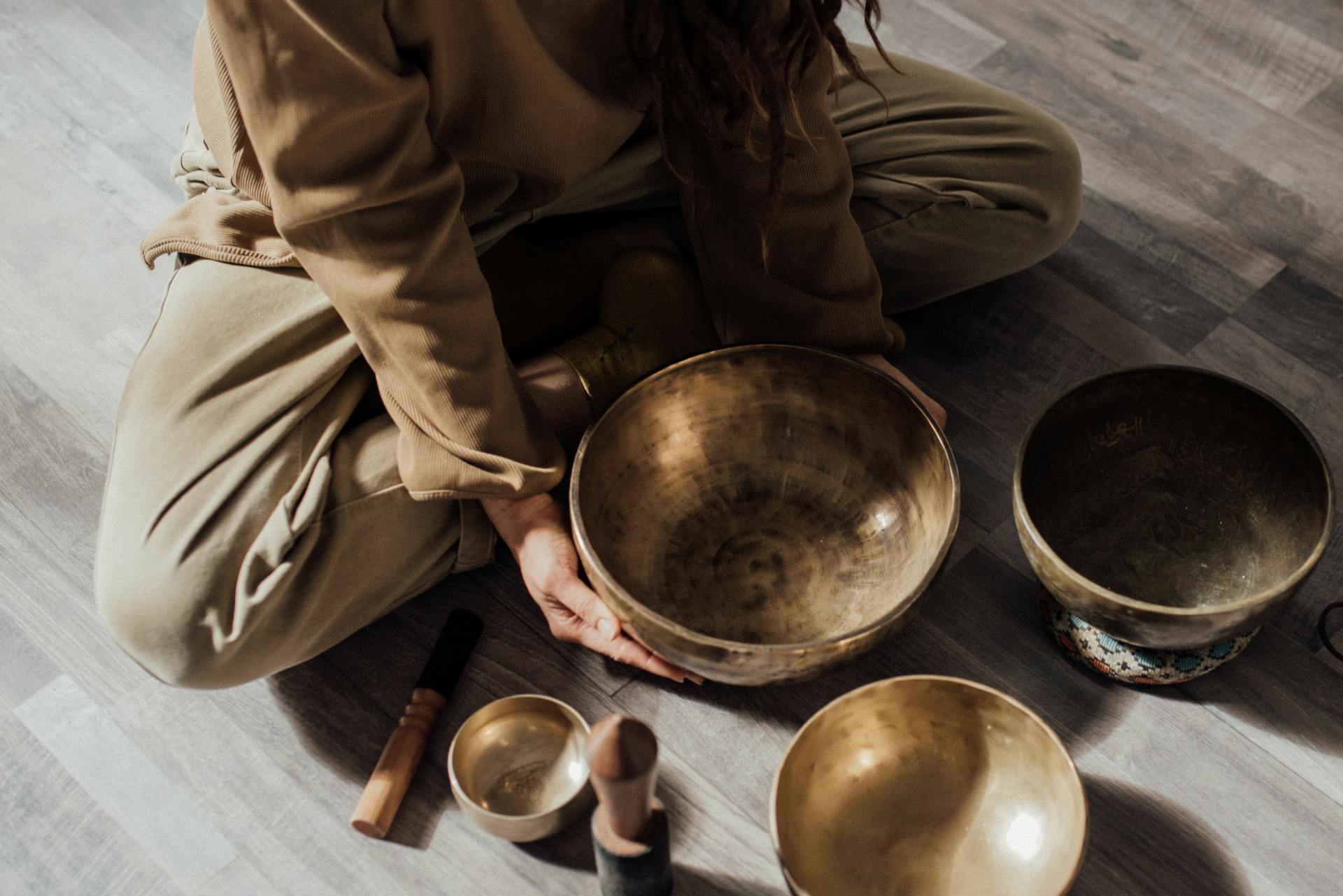 A Person Sitting on the Floor with Metallic Bowls