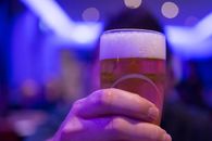 在热闹的夜总会里，一只手握着冒泡的啤酒杯