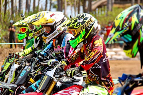 People Sitting on Dirt Bikes Ready to Start a Race