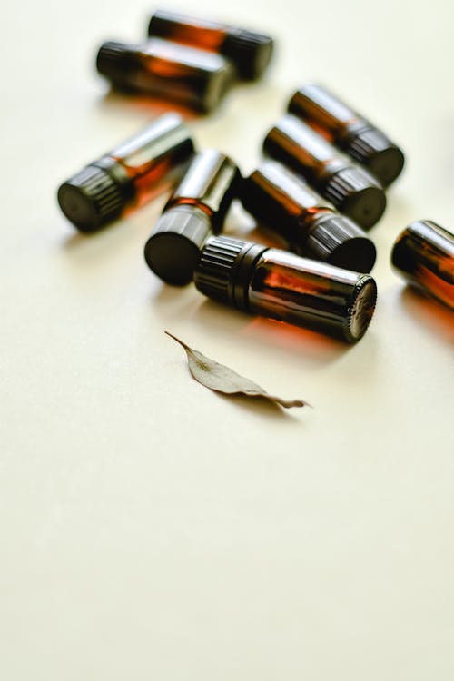 Free Small Bottles beside a Dried Leaf Stock Photo