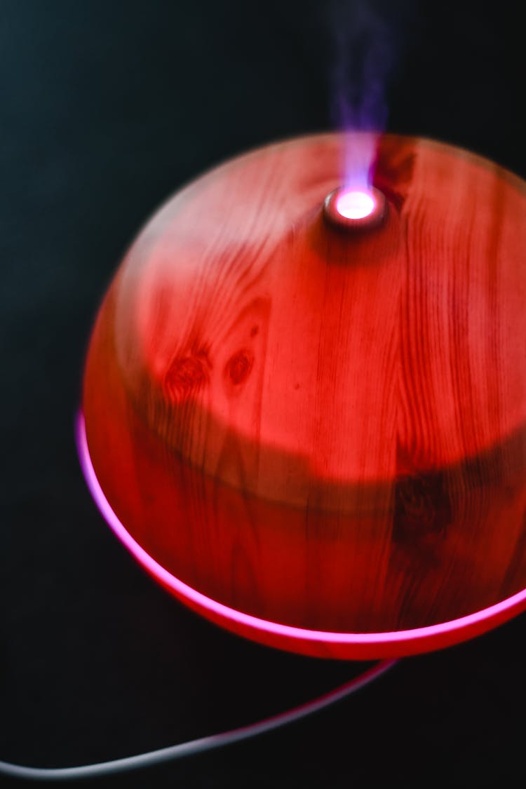 Close-Up Shot Of A Red Essential Oil Diffuser On Black Surface