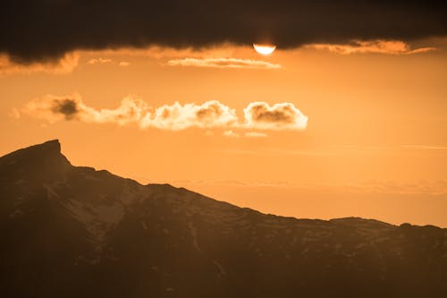 Snowy Mountains Under Orange Sky