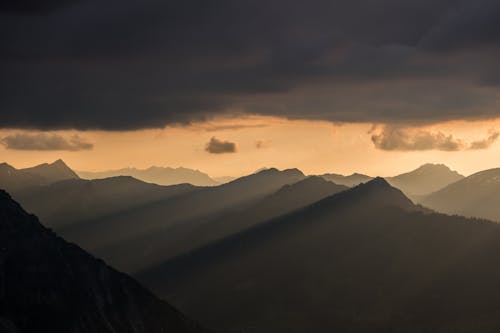 Silhouette of Mountain Ranges Under Gray Clouds during Sunset