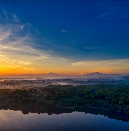Free A breathtaking view of sunset over Banten, Indonesia, with vibrant skies reflecting on a serene lake. Stock Photo