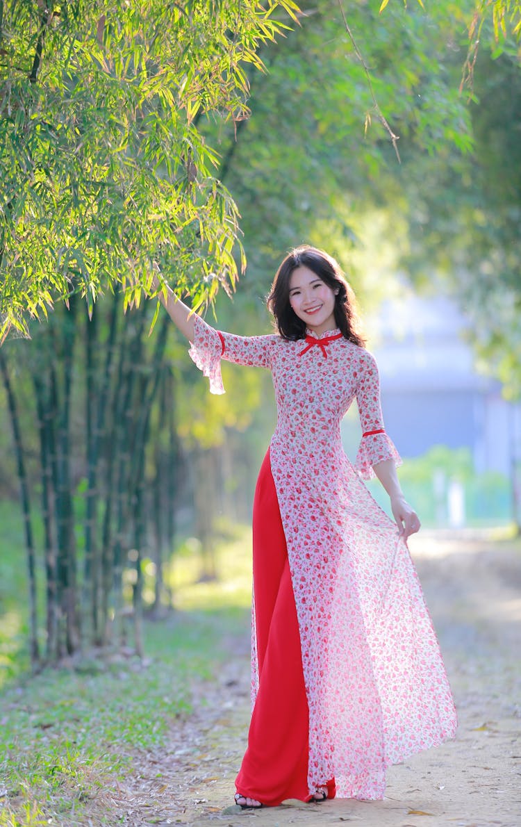 Woman In Pink And White Floral Dress Holding A Green Tree