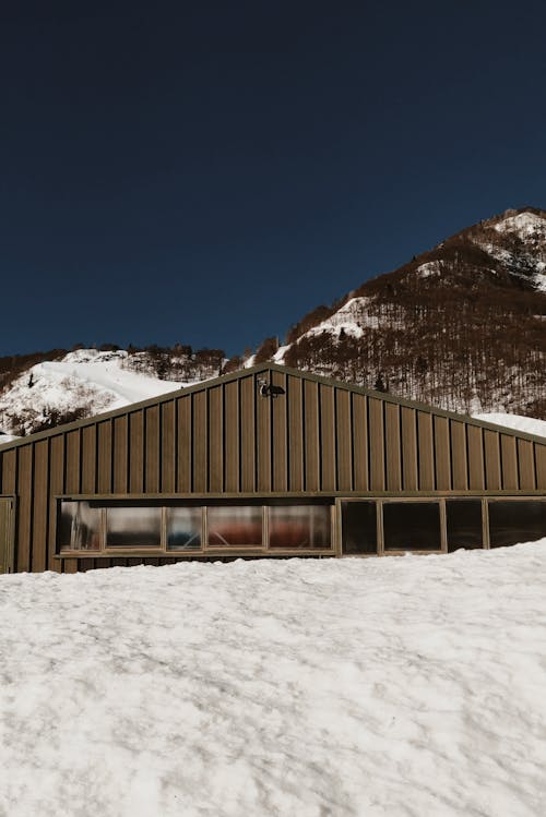 Brown Wooden House on Snow Covered Ground