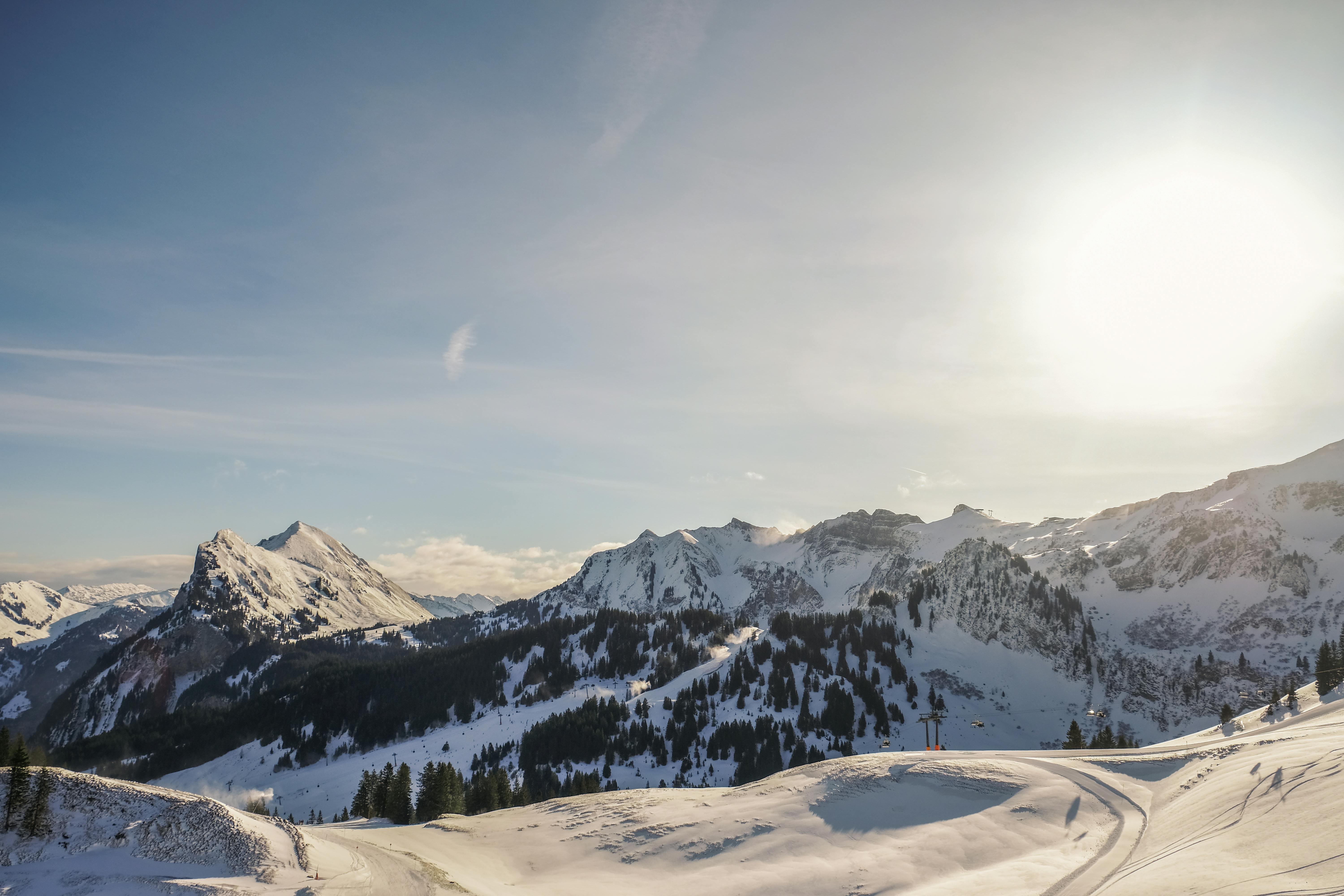 Snow-covered mountain peaks under a bright winter sun, showcasing nature's beauty.