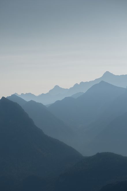 Layered mountain ridges in morning mist — photo by Henrik Pfitzenmaier on Pexels