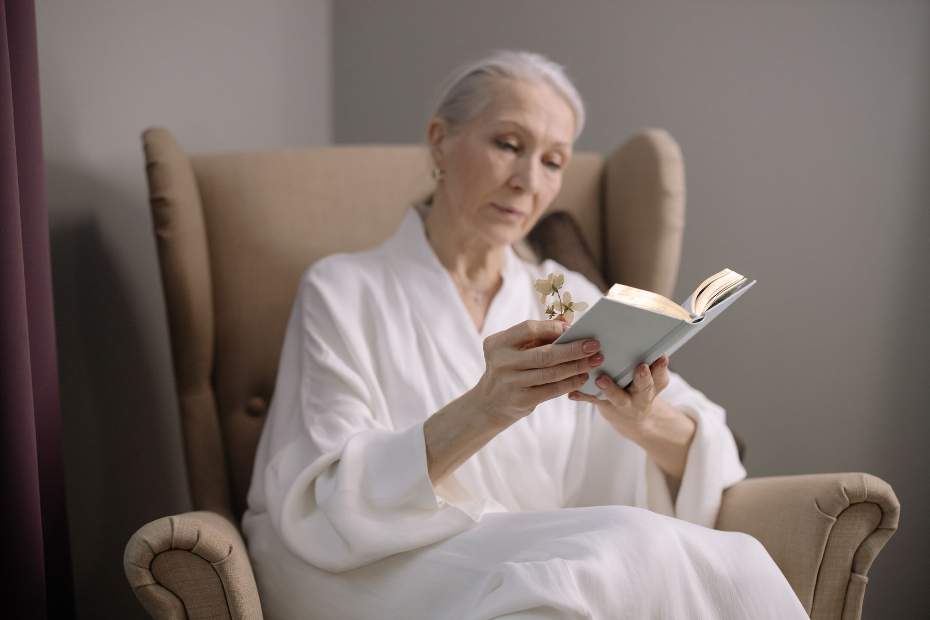 A woman reading in an armchair, enjoying a peaceful indoor moment with a book.