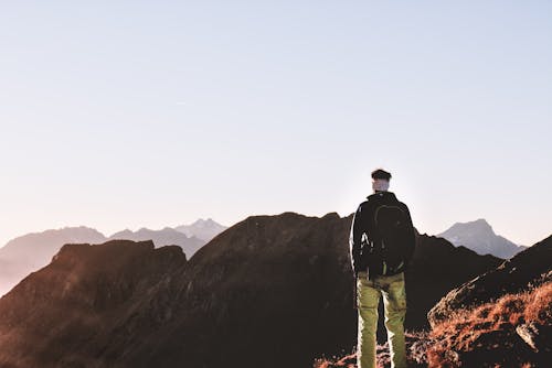 Free Person Standing on Top of the Mountain Stock Photo