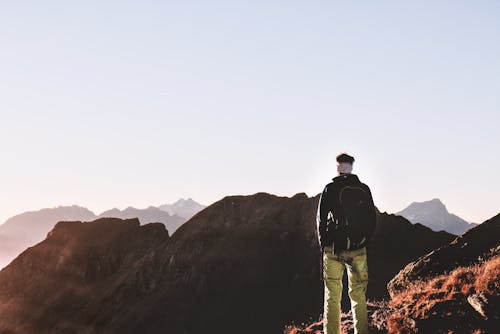 Person Standing on Top of the Mountain