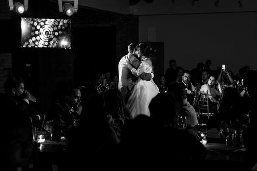 Bride and groom share a romantic dance at a black and white themed wedding reception.