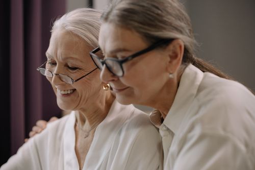 Free Two elderly women wearing glasses share a joyful moment indoors. Stock Photo