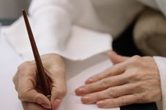 Elegant close-up shot of hands writing a letter using a fountain pen on paper.