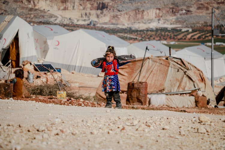 Ethnic Girl Standing Near Refugee Tents