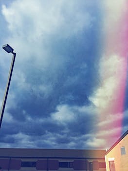 建筑物和灯柱上浮现的一丝彩虹，与令人信服的多云天空共同构成了一场城市戏剧